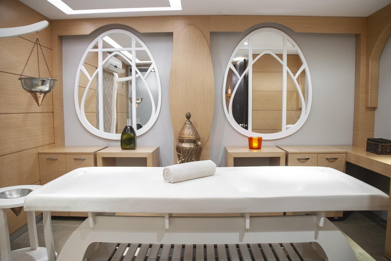 Calm treatment room with a single bed and arched mirrors
