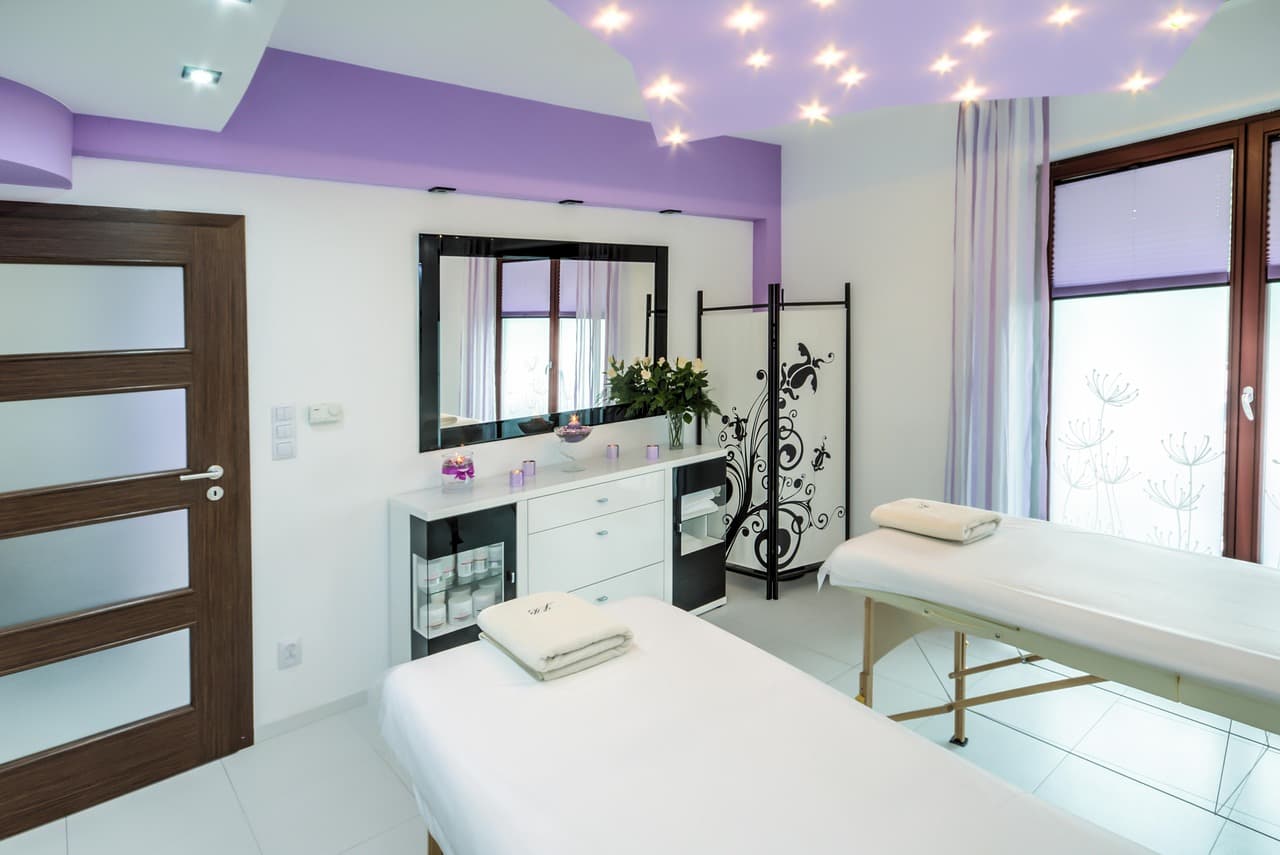 Bright, clean treatment room with a massage bed